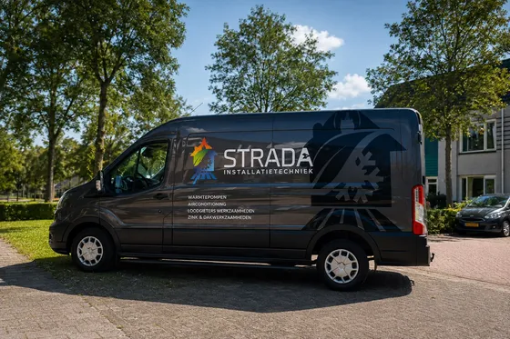 De bedrijfsbus van Strada Installatietechniek, met warmtepompen, airco, loodgieters- en dakwerk op de zijkant